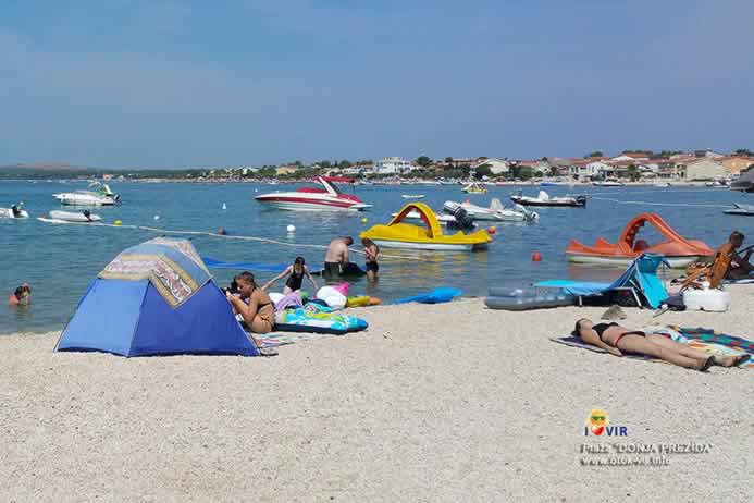 Turisti na šljunčanoj plaži