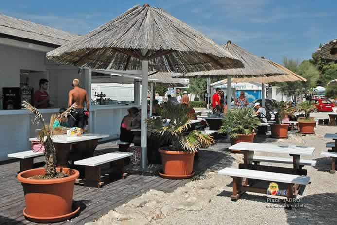 Beach bar šank sa slamnatim suncobranom i garniturama za sjedenje