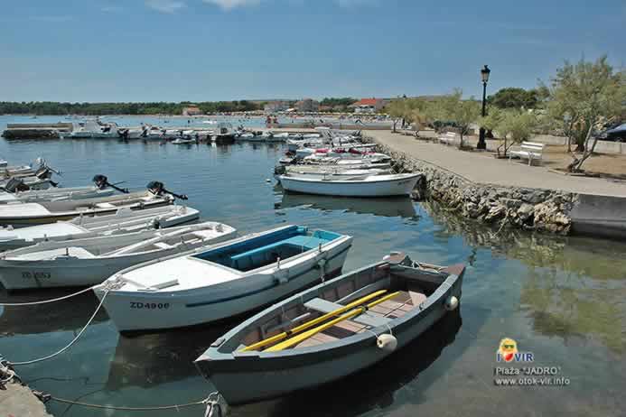 Lučica s čamcima i kamenom uvalom na plaži Jadro