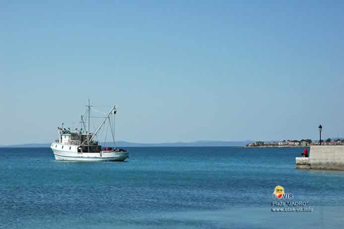 Ribarski brod za sunčanog dana ispred mola na Jadru