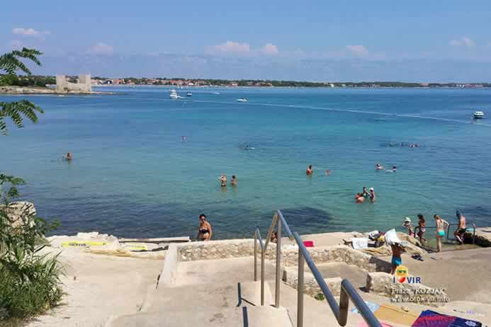 Stepenice prema betonskoj plaži i pogledom na utvrdu Kozjak