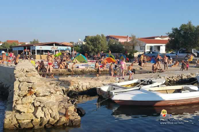 Lučica za brodiće pored plaže za kupanje s turistima