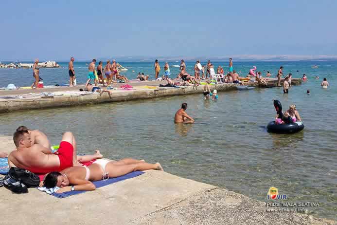 Sunčanje na plaži pored mola