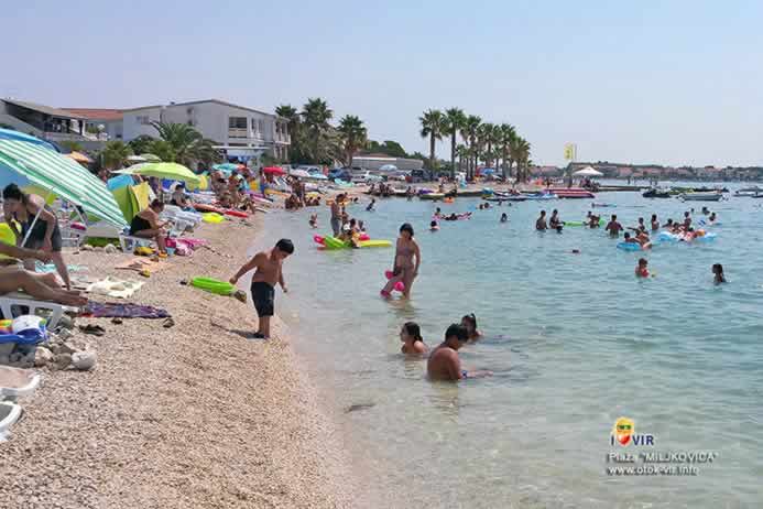 Turisti uživaju s djecom u plićaku na moru