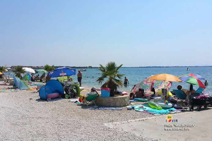 Ljetna plaža puna turista pored makadamske ceste