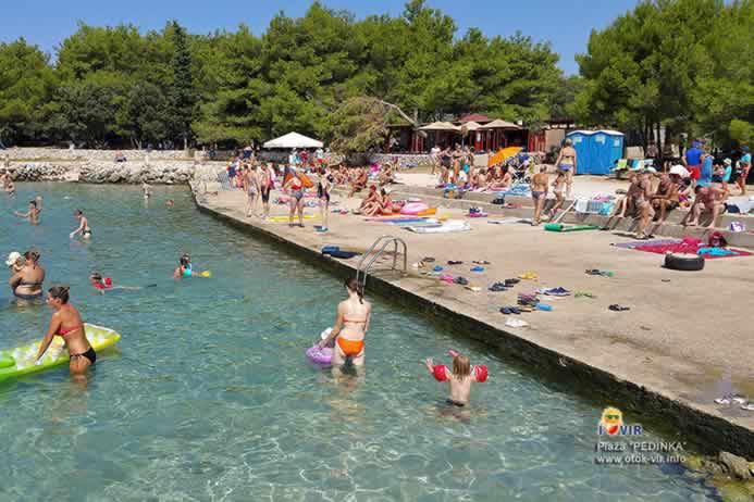 Betonirana plaža s kupačima i dječjim sadržajem