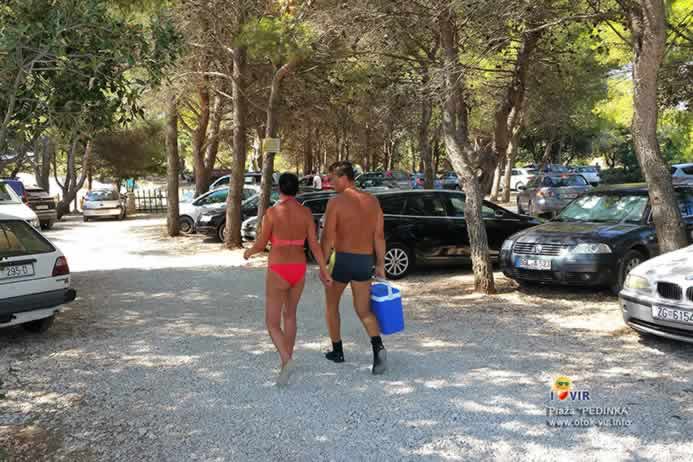 Turisti hodaju kroz parking pokraj plaže