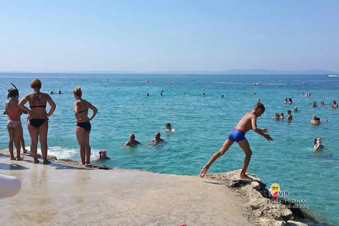 Skakanje u more i kupanje turista na Viru