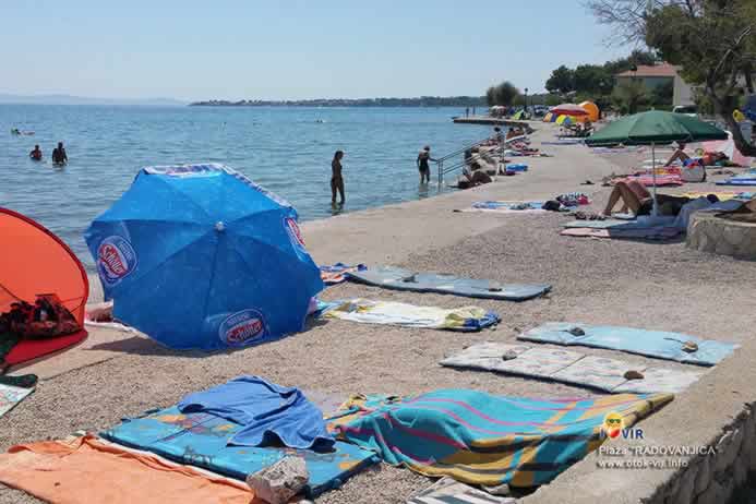 Betonirana plaža sa ručnicima i suncobranima uz more