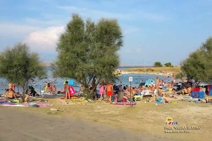 Pješčana cesta do prepune plaže Velika Slatina okružena zelenim tamarisima