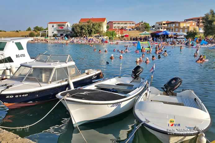 Čamci i gliseri vezani za mol ispred kupališta